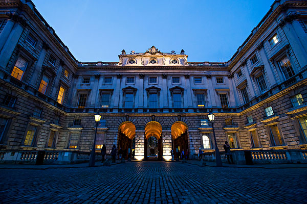 A landscape photo showing the Strand entrance for The Courtauld lit up at night