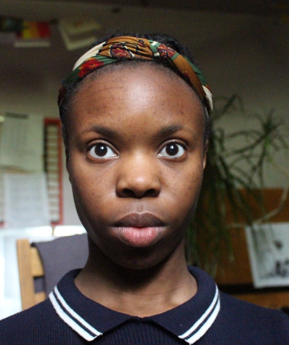 A headshot of Nkechi Nwobani-Akanwo. Nkechi is looking just above the camera view point, with a serious expression. 