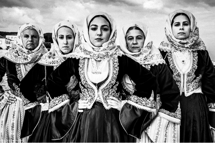 A photo by Georgios Tatakis, one of the selections for the Sony World Photography Awards exhibition 2022. It is a black and white photo of five women wearing traditional Greek dress. Each woman stares intensely at the camera.