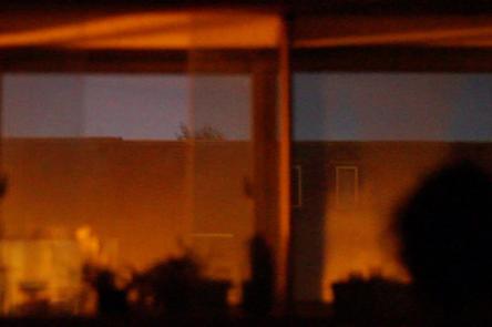 A still from Akinola Davies' film Untitled. Depicts interior reflections against a window and sky.