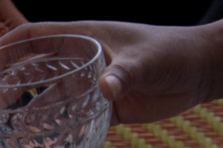 Ana Vaz: Occidente image A still from Ana Vaz's Occidente. It shows a hand holding a crystal cut glass.