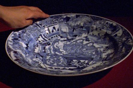 A still from Occidente by Ana Vaz. It shows a hand holding a china plate.