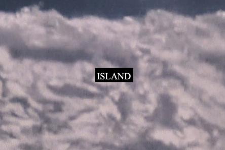 A still from Laura Grace Ford & Sam William's film ISLAND. It shows a fuzzy cloud-like substance with word ISLAND printed on it