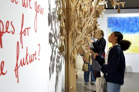 A photo showing a young person observing a wall mural at the National Saturday Club Summer Show 2022