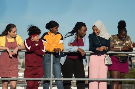 A still from Rocks. A group of girls on a rooftop, smiling.