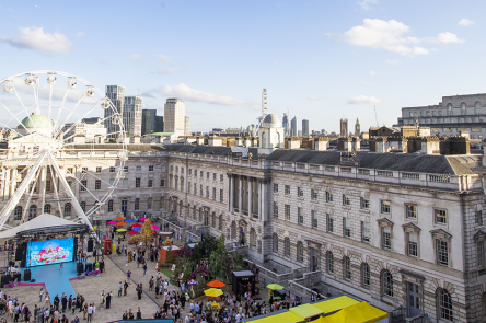 A photo of Somerset House's courtyard from the roof of the Courtauld (North Wing building). At the centre of the courtyard ia giant ferris wheel and crowds are gathering in the courtyard.