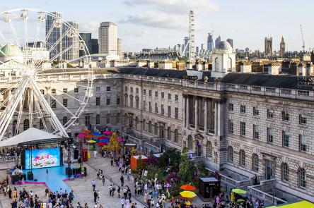 An aerial photo of Somerset House's courtyard, taken by Chloe Hashemi. Below you can see a big ferris wheel, a stage, and crowds of people gathering. The skies are 