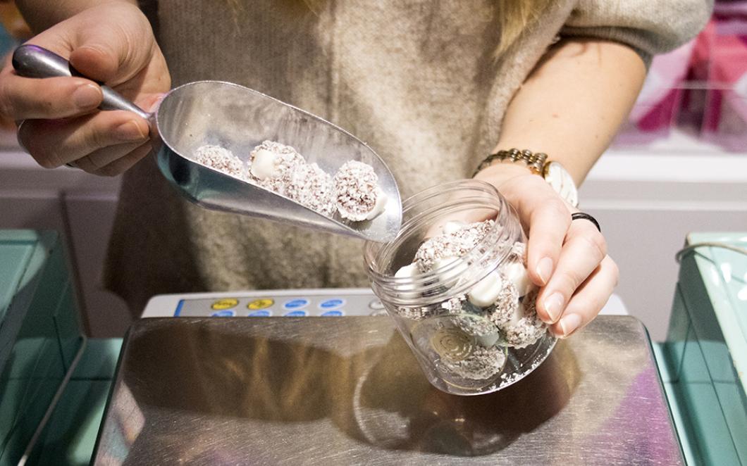 A person measure out mushroom sweets in Sugar Sin sweet shop