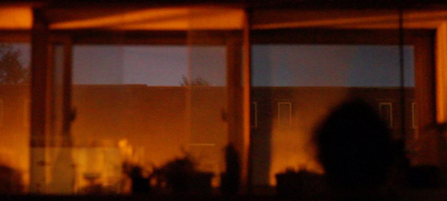 A still from Akinola Davies' film Untitled. Depicts interior reflections against a window and sky.