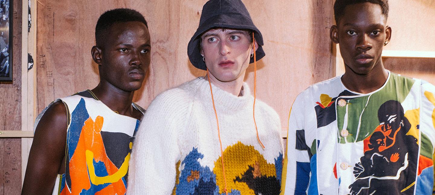 A photo of 3 men wearing patterned clothes at a fashion show, designed by Bethany Williams