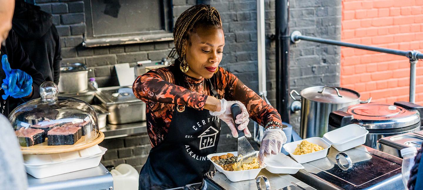 A photo of a woman serving food and smiling