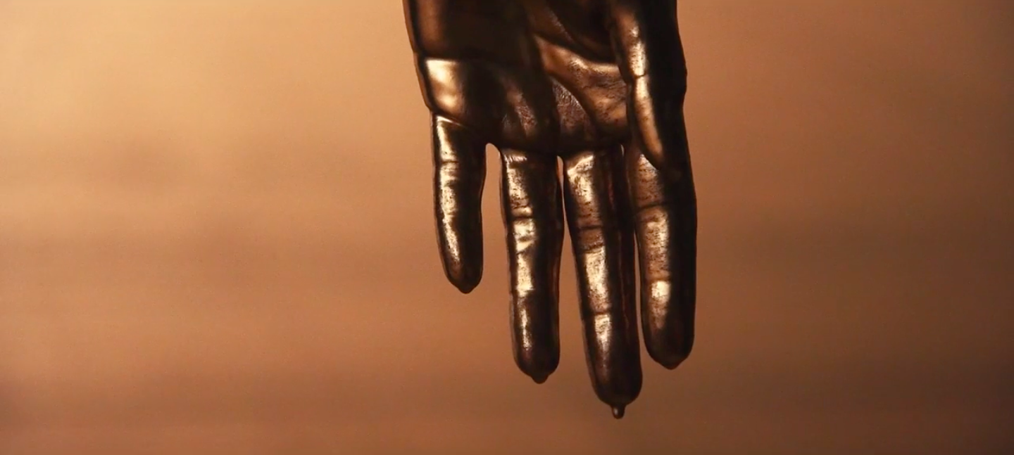 Still from Next Round, 2020, short film, collaboration between Sophia Al- Maria, Tosh Basco, Wu Tsang, with music by their long-time collaborator Patrick Belaga. A  hand drips with metallic paint.