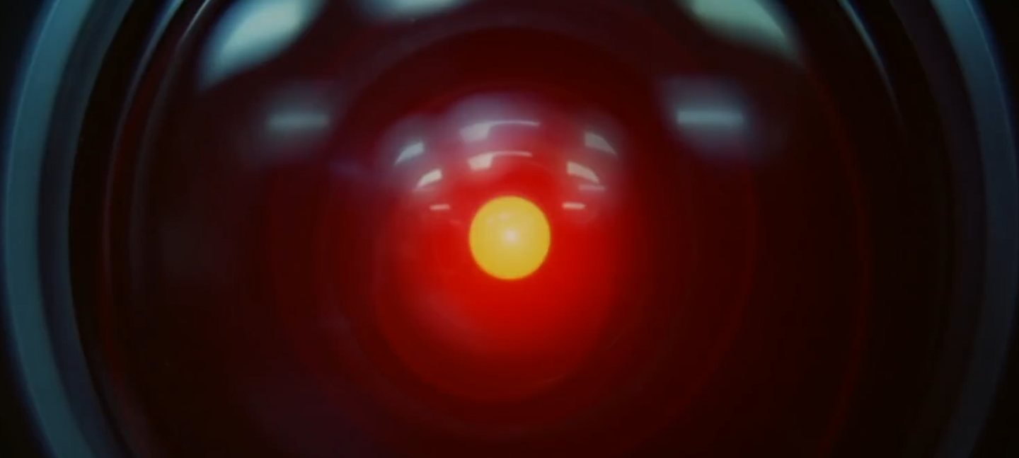 A still from 2001: A Space Odyssey, used as a reference for not/nowhere's episode of Transmissions. A close up of HAL. An ominous red light sits at the centre of a camera lens, unblinking.