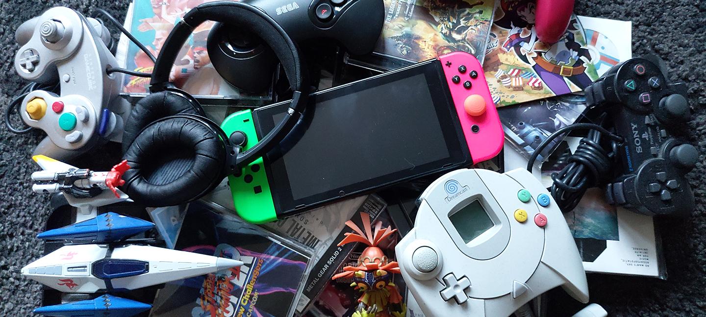 A pile of old video game controllers and headphones