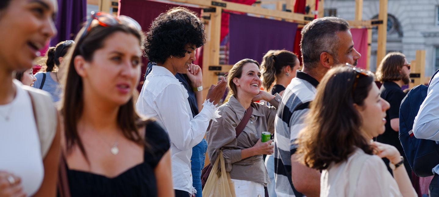 A group of visitors enjoying the evening sunshine in the courtyard at Somerset House during a Morgan Stanley Lates