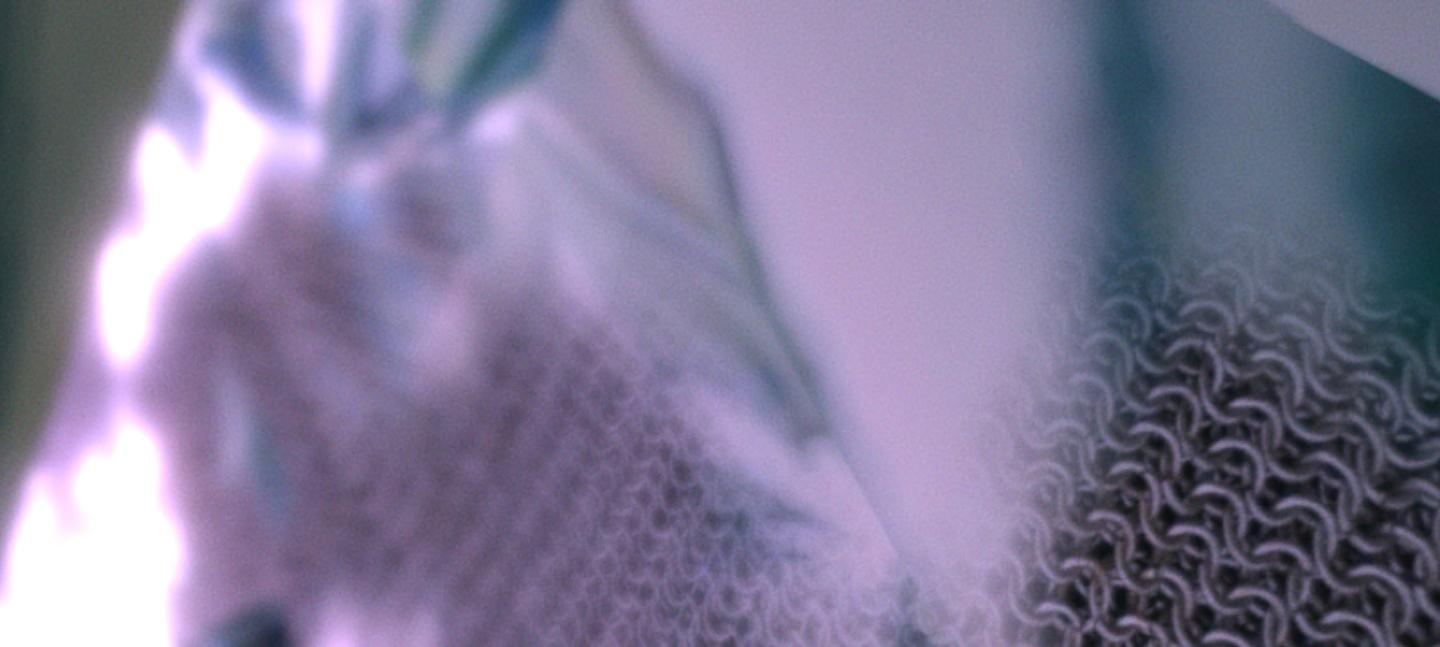 A blurred close-up of some knitted fabric in a blue, grey palette