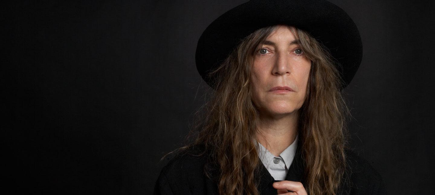 A portrait of Patti Smith in a black hat by photographer Edward Mapplethorpe