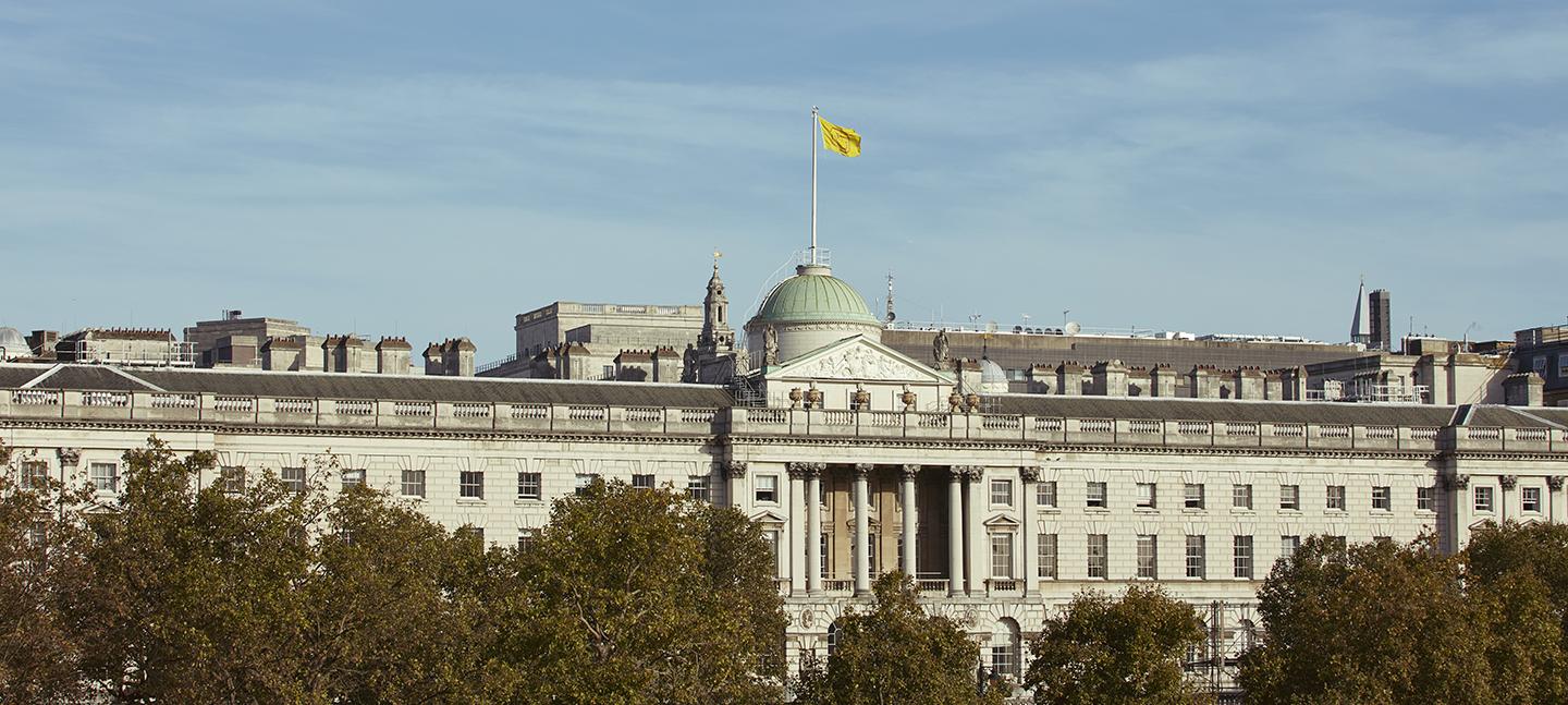 A photo of Somerset House courtyard at twilight, with fountains on.