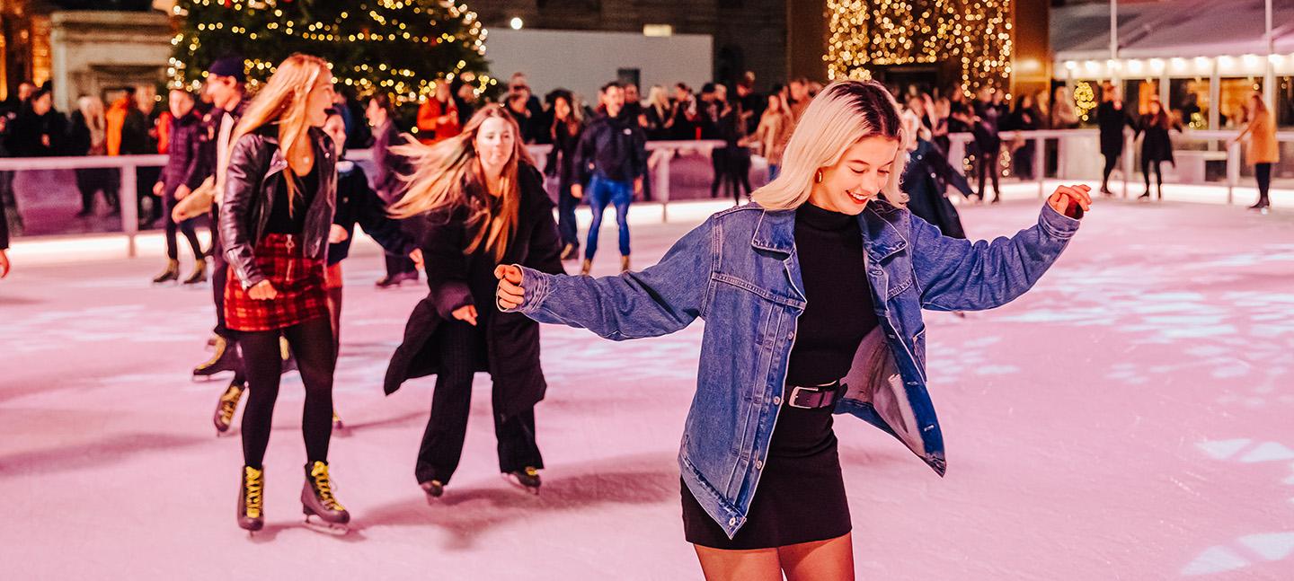 Young women on the ice at Somerset House enjoying themselves.