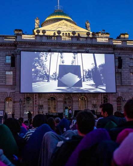 People watching a film on an outdoor cinema screen at Film4 Summer Screen at Somerset House