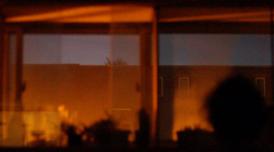 A still from Akinola Davies' film Untitled. Depicts interior reflections against a window and sky.