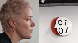 A film still from Emma Hart: Language and Class. On the left hand side is a profile view of the artist Emma Hart, a woman with short blonde hair, who is mid-speech. On the right-handside is a ceramic artwork that spells OI OI