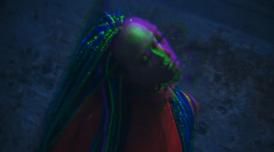 A photo of GLOR1A. She has her eyes closed and there is a graphic blur effect adding a reflection / double of her face