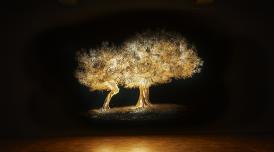 An installation photo of Greece's Pavilion. A luminous tree grows on a black background.