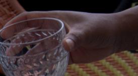 A still from Ana Vaz's Occidente. It shows a hand holding a crystal cut glass.
