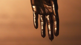 Still from Next Round, 2020, short film, collaboration between Sophia Al- Maria, Tosh Basco, Wu Tsang, with music by their long-time collaborator Patrick Belaga. A  hand drips with metallic paint.