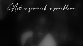 A black and white image of a blurred face wearing a white t-shirt and smiling. Above the image are the words 'Not a gimmick a punchline' in cursive writing