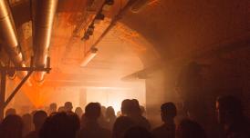 Crowd of people at a lice music event with lasers and smoke in The Deadhouse at Somerset House