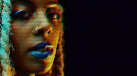 A photo of Juliana Huxtable, with a glitch effect and a black background.