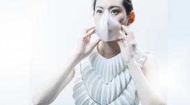 A woman in white wearing a futuristic breathing mask 