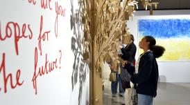 A photo showing a young person observing a wall mural at the National Saturday Club Summer Show 2022