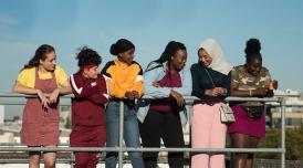 A still from Rocks. A group of girls on a rooftop, smiling.