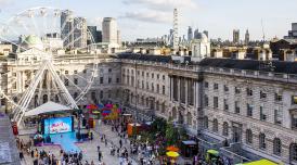 An aerial photo of Somerset House's courtyard, taken by Chloe Hashemi. Below you can see a big ferris wheel, a stage, and crowds of people gathering. The skies are 